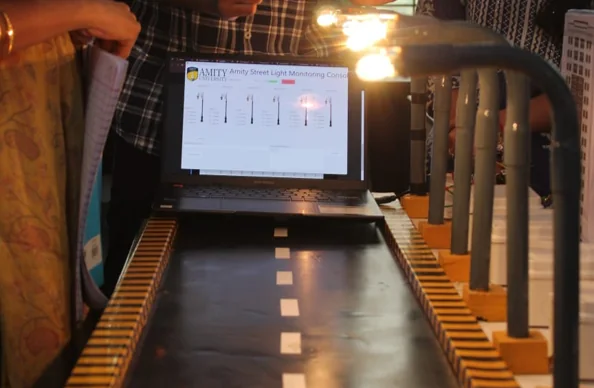 Original AIDC streetlight monitoring prototype with an illuminated scale model and operator dashboard